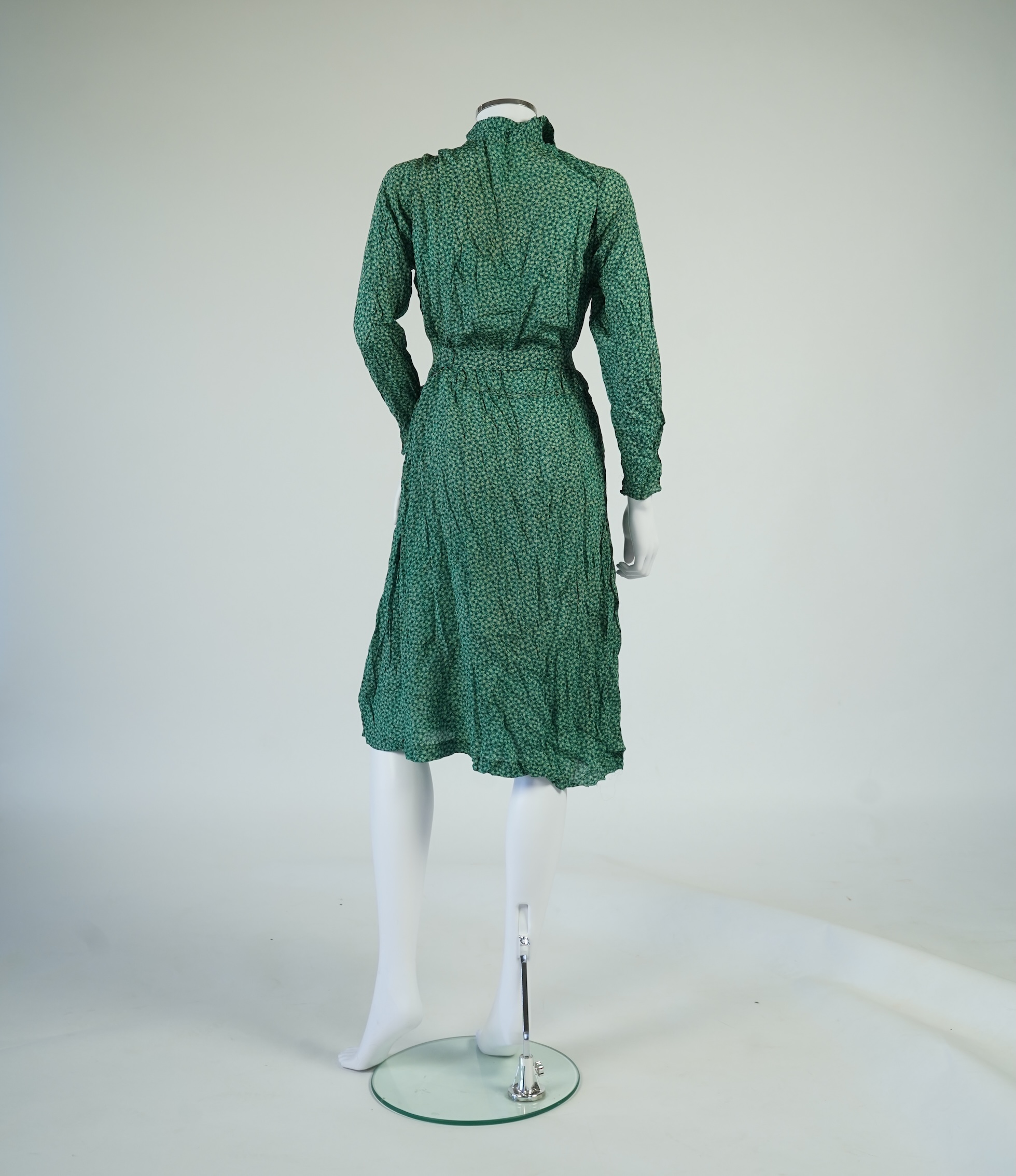 Two 1930's printed silk crepe summer day dresses together with a similar pale blue and black stripped summer day dress., Condition - the maroon and cream dress has damage to one sleeve, the green dress has worn under the